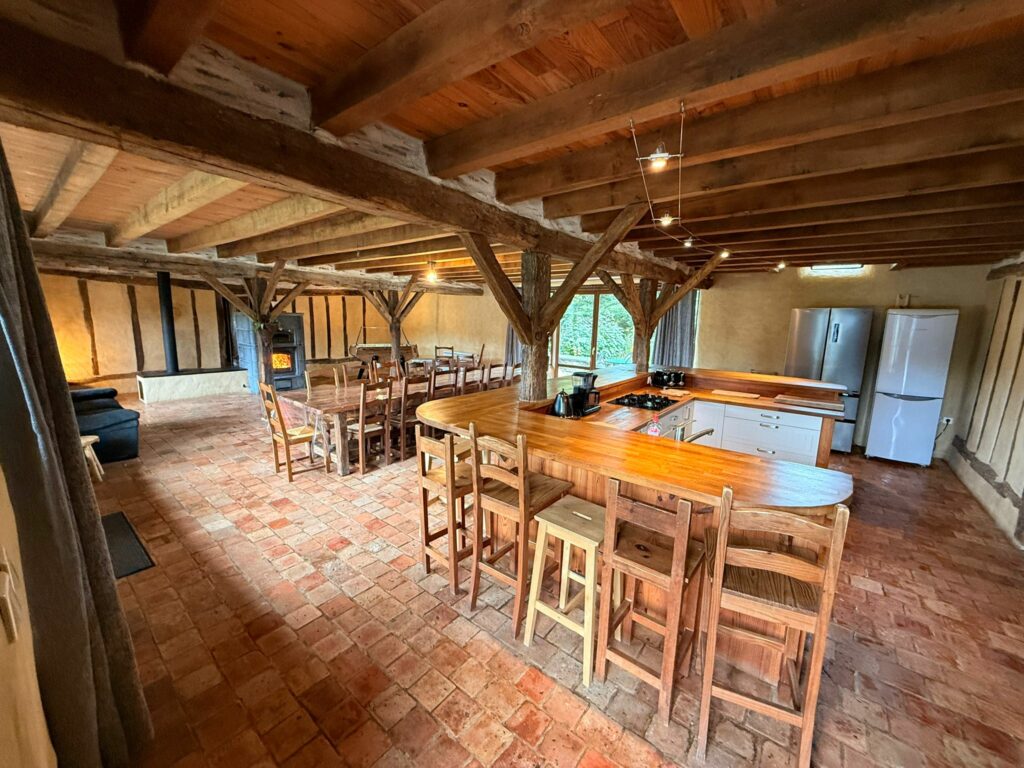 Bar et cuisine ouverte sur la grande salle aux tomettes