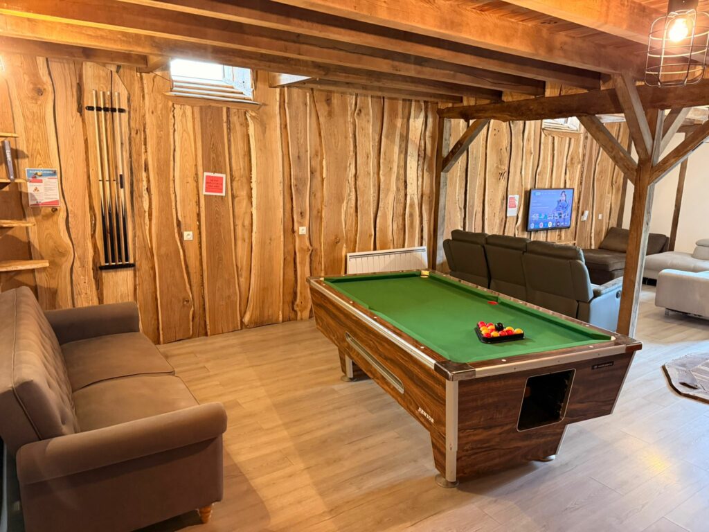 La salle de jeux avec le billard sous les poutres